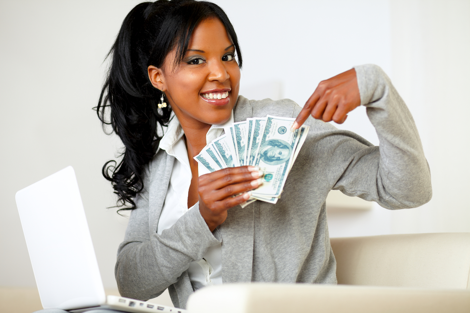 Portrait of a happy woman pointing plenty of cash money